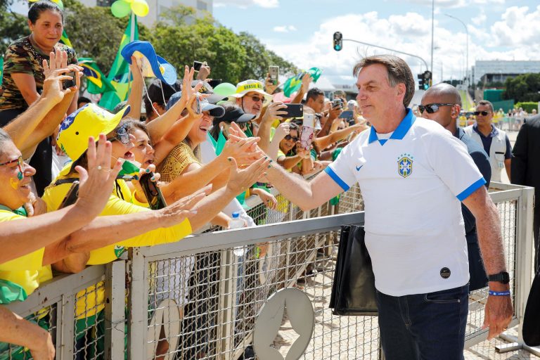 O presidente Bolsonaro confraterniza com manifestantes contrariando orientação do Ministério da Saúde: pesquisa mostrou que pessoas que não confiavam no governo não cumpriam o distanciamento social (Foto: Sergio Lima/AFP)