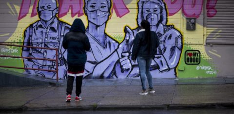 Duas mulheres no Harlem, em Nova York, observam o mural do artista @Dister, retratando socorristas com máscaras e uma mensagem de agradecimento. Foto Johannes Eisele/AFP