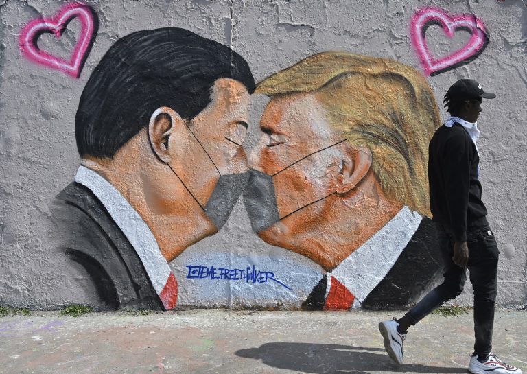 Em Berlim, uma pintura mural do grafiteiro Eme Freethinker apresenta imagens do presidente dos EUA, Donald Trump, e do premier chinês, Xi Jinping, usando máscaras contra a covid-19. Foto John MacDougall/AFP