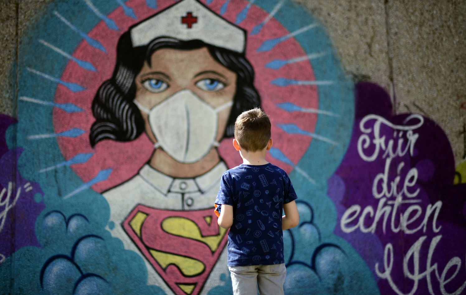 O grafite pintado pelo artista Kai 'Uzey', na Alemanha, chama a atenção do jovem passante. Foto Ina Fassbender/AFP