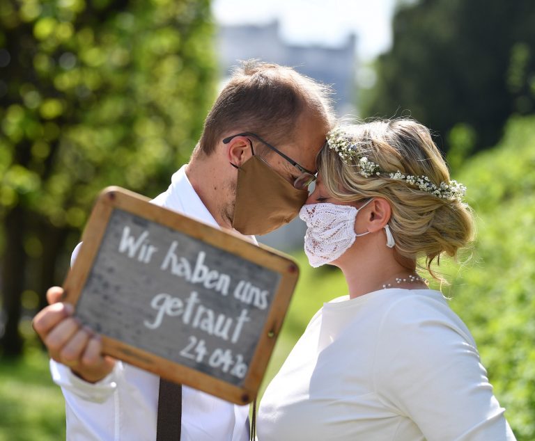 O casal austríaco Sigrun e Franz faz a sua cerimônia de casamento em meio à pandemia. No cartaz: "Nós ousamos". Foto Barbara Gindl/AFP
