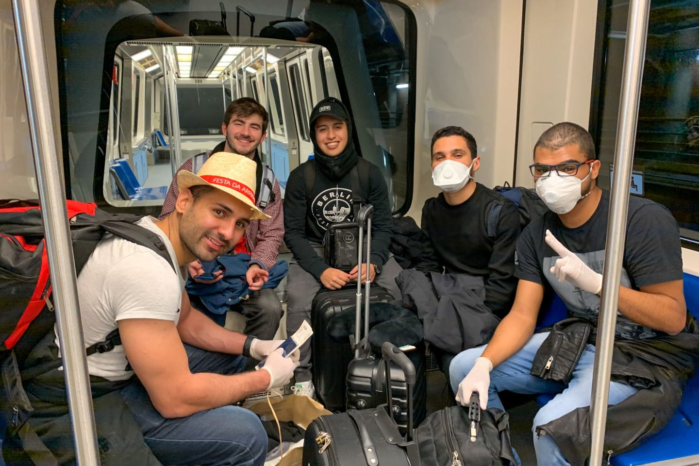 Carioca da Cidade de Deus, Matheus (segundo à direita, de máscara) no aeroporto de Madri com um amigo bolsista e outros brasileiros: sonho de estudar no exterior adiado (Foto: Lethicia Amancio)