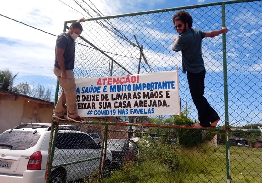 Integrantes do grupo Movimenta Caxias pendura faixa em bairro da periferia: ações para apoiar e conscientizar (Foto: Reprodução/Facebook)