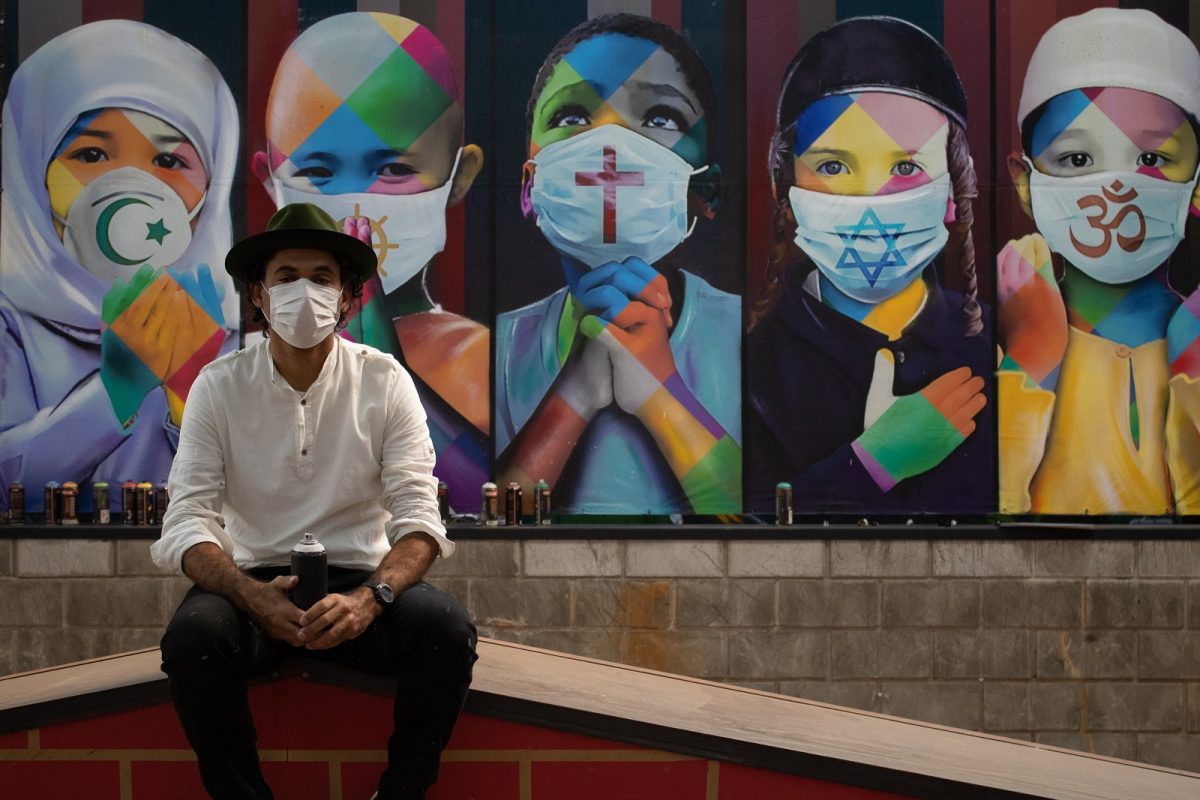 O artista brasileiro Eduardo Kobra posa diante da sua obra Coexistencia, na cidade de Itu, em São Paulo. Foto Rebeca Reis/AGIF