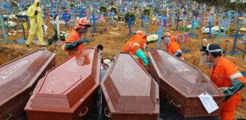 Caixões com vítimas da covid-19 são descarregados para serem enterrados em uma vala comum no cemitério de Nossa Senhora da Piedade, em Manaus. Foto Michael Dantas/AFP