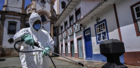 Membro de uma equipe de limpeza ajuda a desinfetar o centro histórico de Ouro Preto. Foto Douglas Magno/AFP