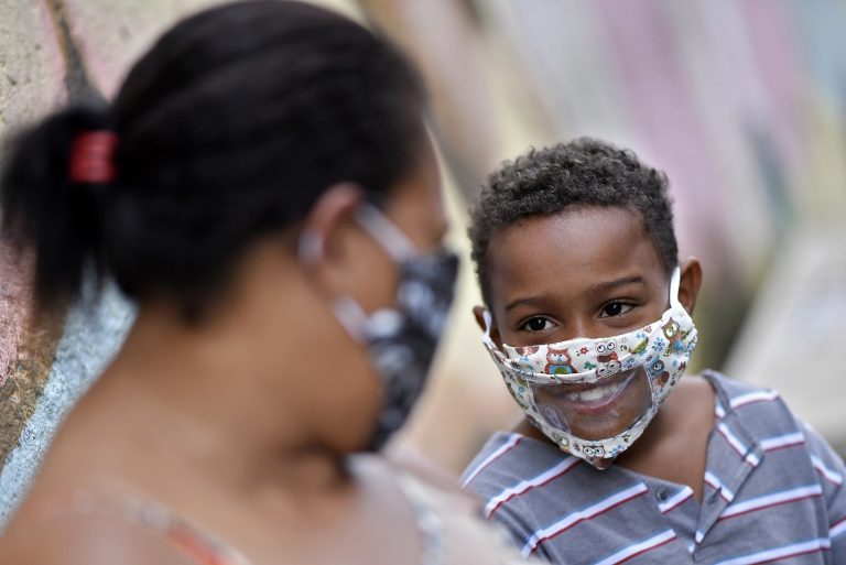 Em Belo Horizonte, Juliene Maria Conceição, que sofre de deficiência auditiva, sorri para o filho Leonardo. Ambos com máscaras protetoras contra a covid-19, projetadas para que os lábios possam ser lidos. Foto Douglas Magno/AFP