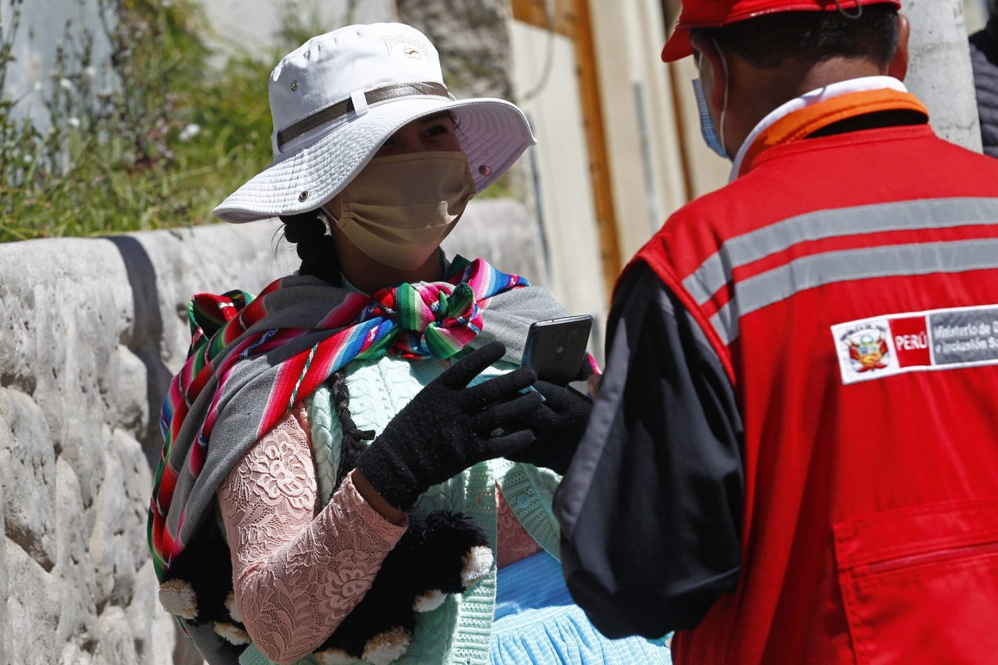 Uma mulher é entrevistada por funcionários do Ministério da Mulher e das Populações Vulneráveis enquanto ocupa um lugar na fila fora de uma instituição Administradora de Fundos de Pensão na cidade andina de Puno, perto da fronteira com a Bolívia. Foto Carlos Mamani/AFP