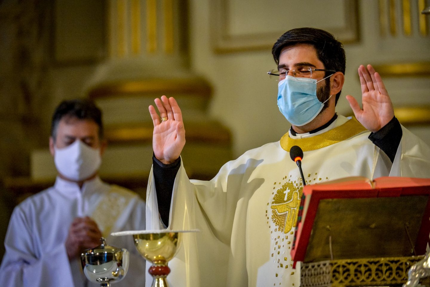 O padre Lucas Mendes, usando uma máscara protetora, celebra a missa na igreja de Nossa Senhora das Dores, em Porto Alegre. Foto Sílvio Avila/AFP