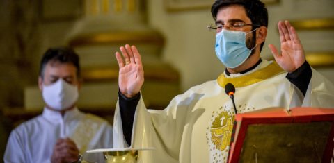 O padre Lucas Mendes, usando uma máscara protetora, celebra a missa na igreja de Nossa Senhora das Dores, em Porto Alegre. Foto Sílvio Avila/AFP