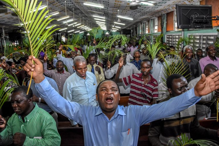 Fiéis oram sem usar máscaras e sem respeitar o distanciamento social durante uma missa do Domingo de Ramos na Igreja do Evangelho Completo, em Dar es Salaam, na Tanzânia. Foto Ericky Boniphace/AFP