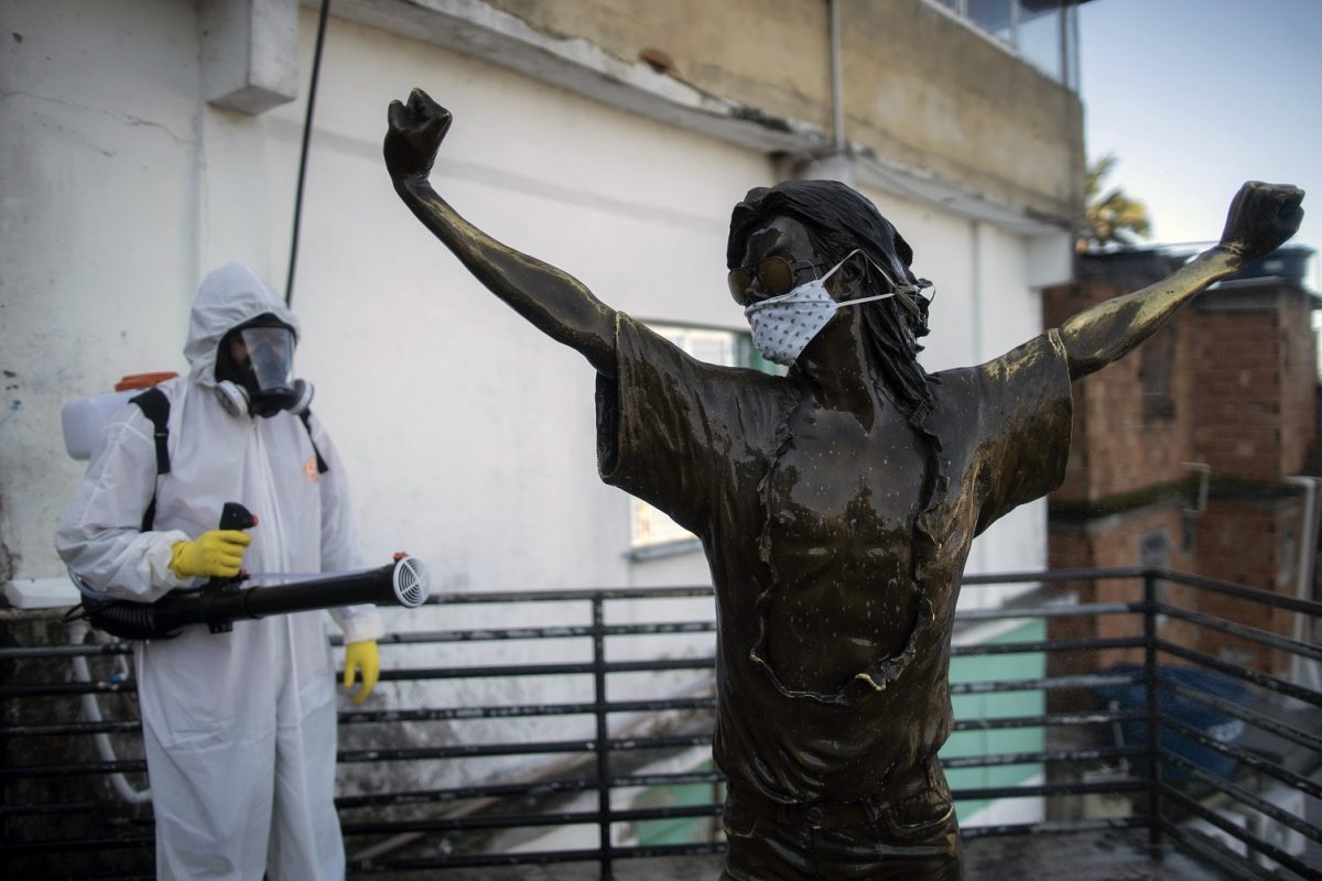 Voluntário desinfeta a estátua de Michael Jackson na favela Santa Marta, no Rio de Janeiro. Foto Mauro Pimentel