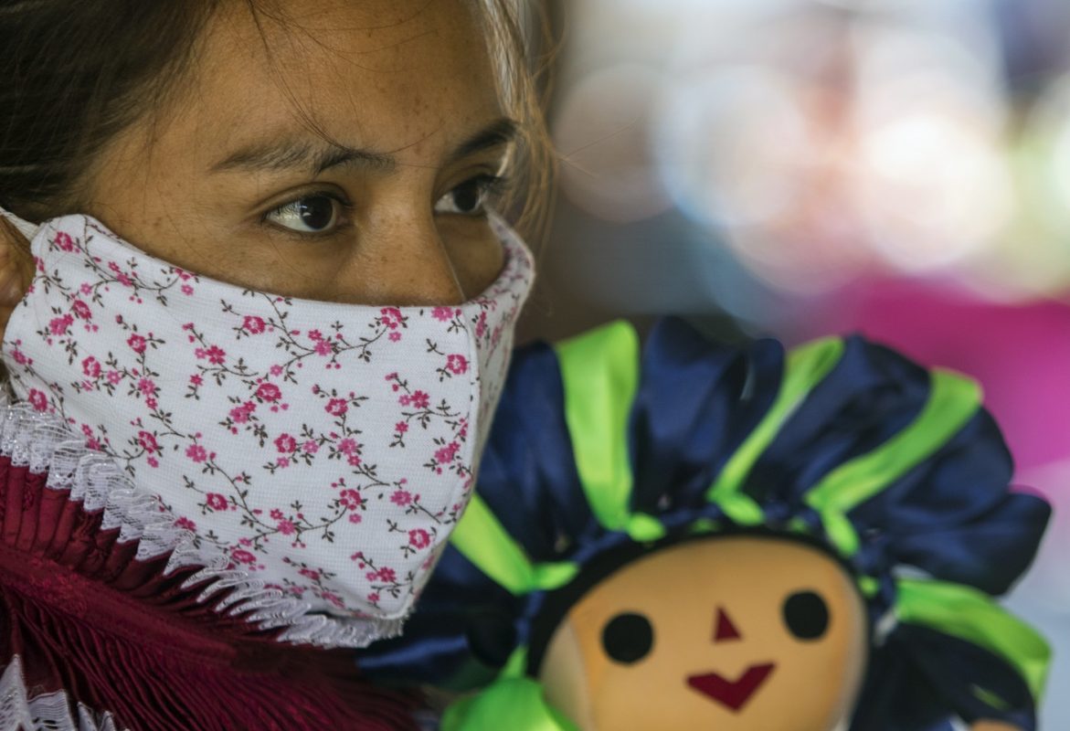 Na Cidade do México, a indígena Otomi Maricela Pere, usa uma máscara facial contra a disseminação do coronavírus enquanto tenta vender as suas peças de artesanato. Foto Claudio Cruz/AFP
