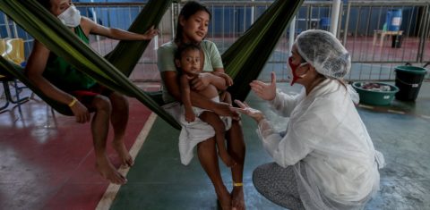 Em Manaus, representante do Médicos Sem Fronteiras examina uma criança da tribo Warao, o segundo maior grupo indígena da Venezuela, que sofre com sintomas do coronavírus. Foto Michael Dantas/AFP