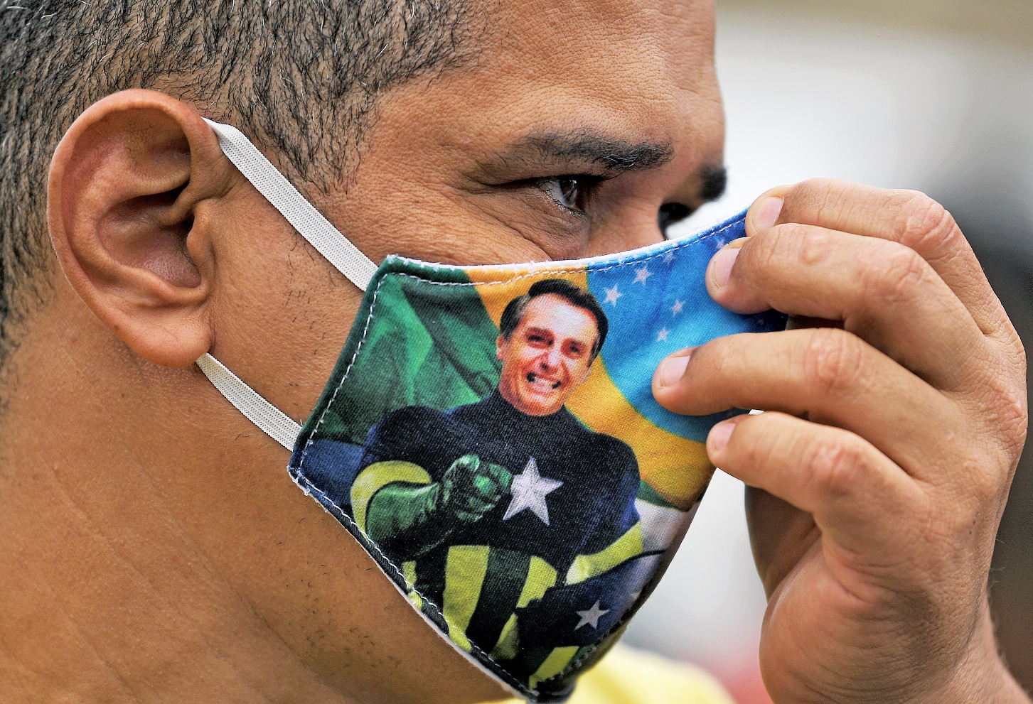 Apoiador do presidente Bolsonaro usa uma máscara de proteção contra o coronavírus em manifestação no Rio. Foto Carl de Souza/AFP