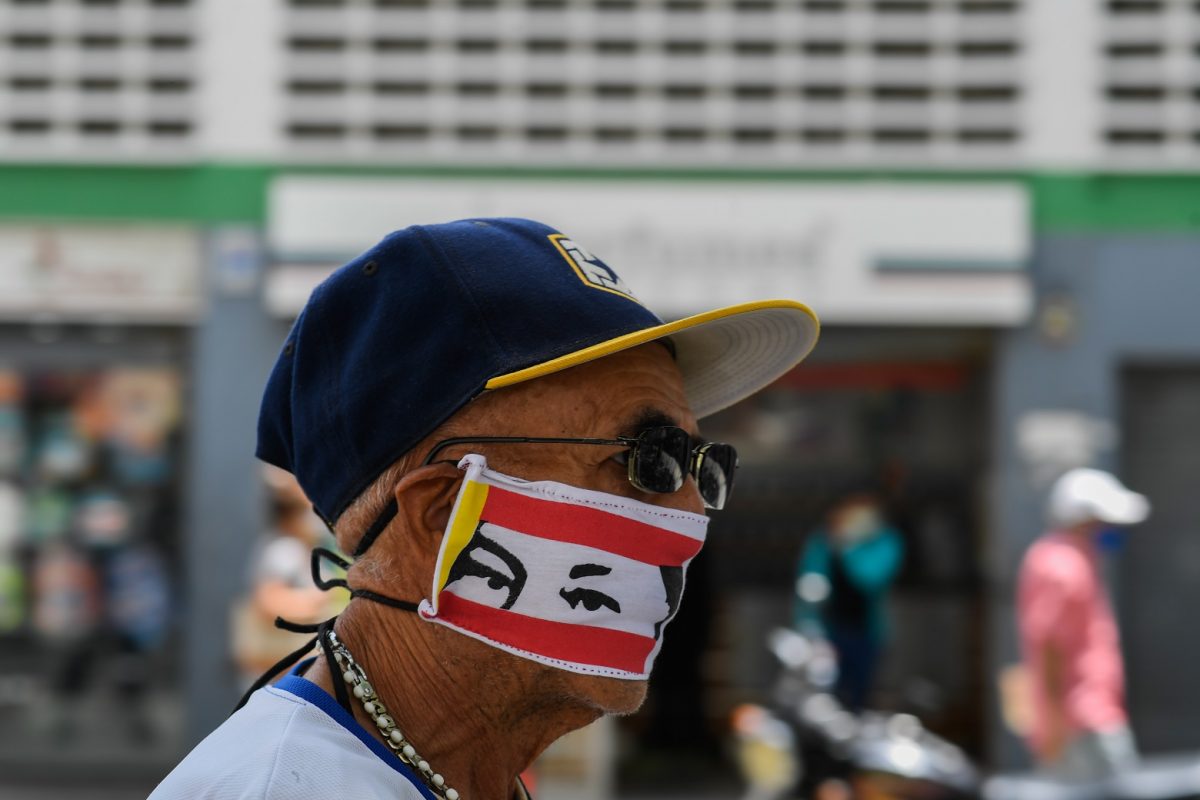 Em Caracas, um homem usa uma máscara com o rosto do ex-presidente Hugo Chaves, após a flexibilização da quarentena no país. Foto Federico Parra/AFP