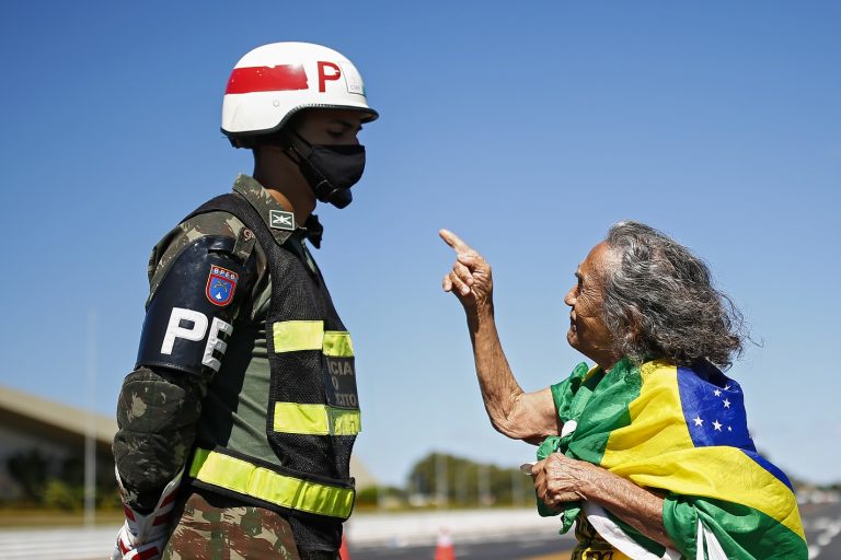 Uma apoiadora do presidente Jair Bolsonaro discute com um soldado, em Brasília, durante uma manifestação contra o governador Ibaneis Rocha. Foto Sérgio Lima/AFP