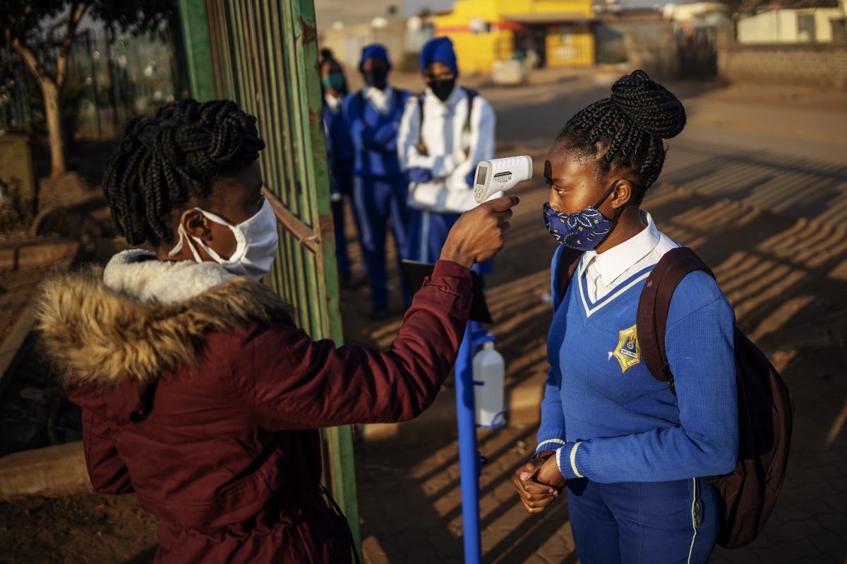 Uma aluna da Escola Secundária Winnie Mandela tem sua temperatura medida antes da entrada após o recomeço das aulas no município de Tembisa, Ekurhuleni, na África do Sul. Foto Michele Spatari/AFP