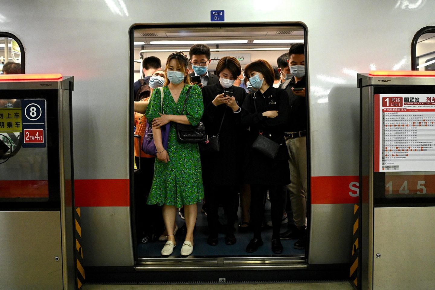 Passageiros usando máscara viajam na hora do rush no metrô de Pequim. Foto Noel Celis/AFP