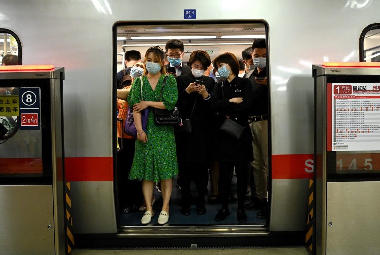 Passageiros usando máscara viajam na hora do rush no metrô de Pequim. Foto Noel Celis/AFP