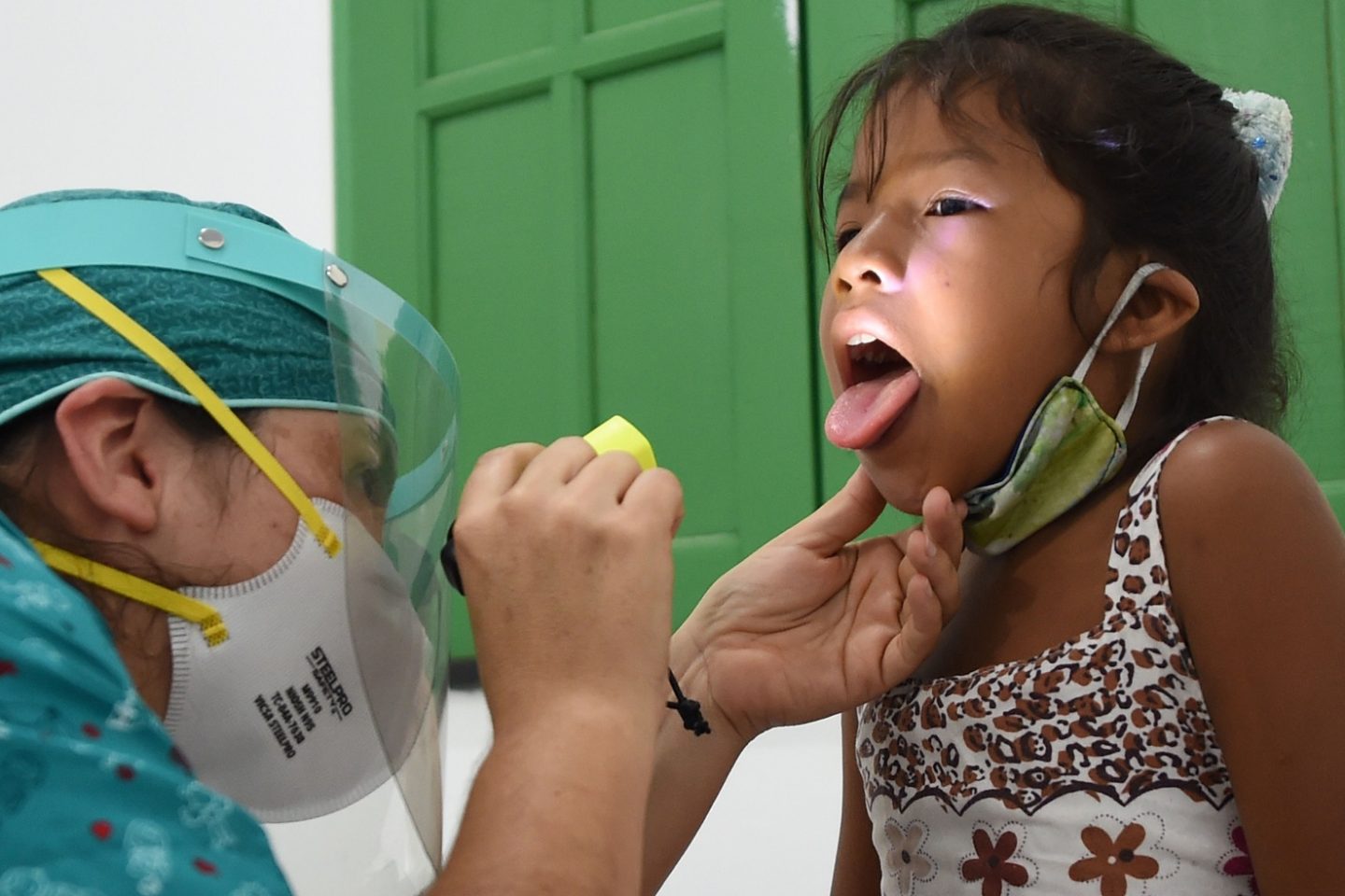 Uma menina indígena da tribo Ticuna recebe assistência médica em um posto de saúde na vila de Umariacu, em Tabatinga, no Amazonas. Foto Evaristo Sá/AFP