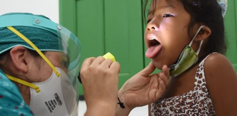 Uma menina indígena da tribo Ticuna recebe assistência médica em um posto de saúde na vila de Umariacu, em Tabatinga, no Amazonas. Foto Evaristo Sá/AFP