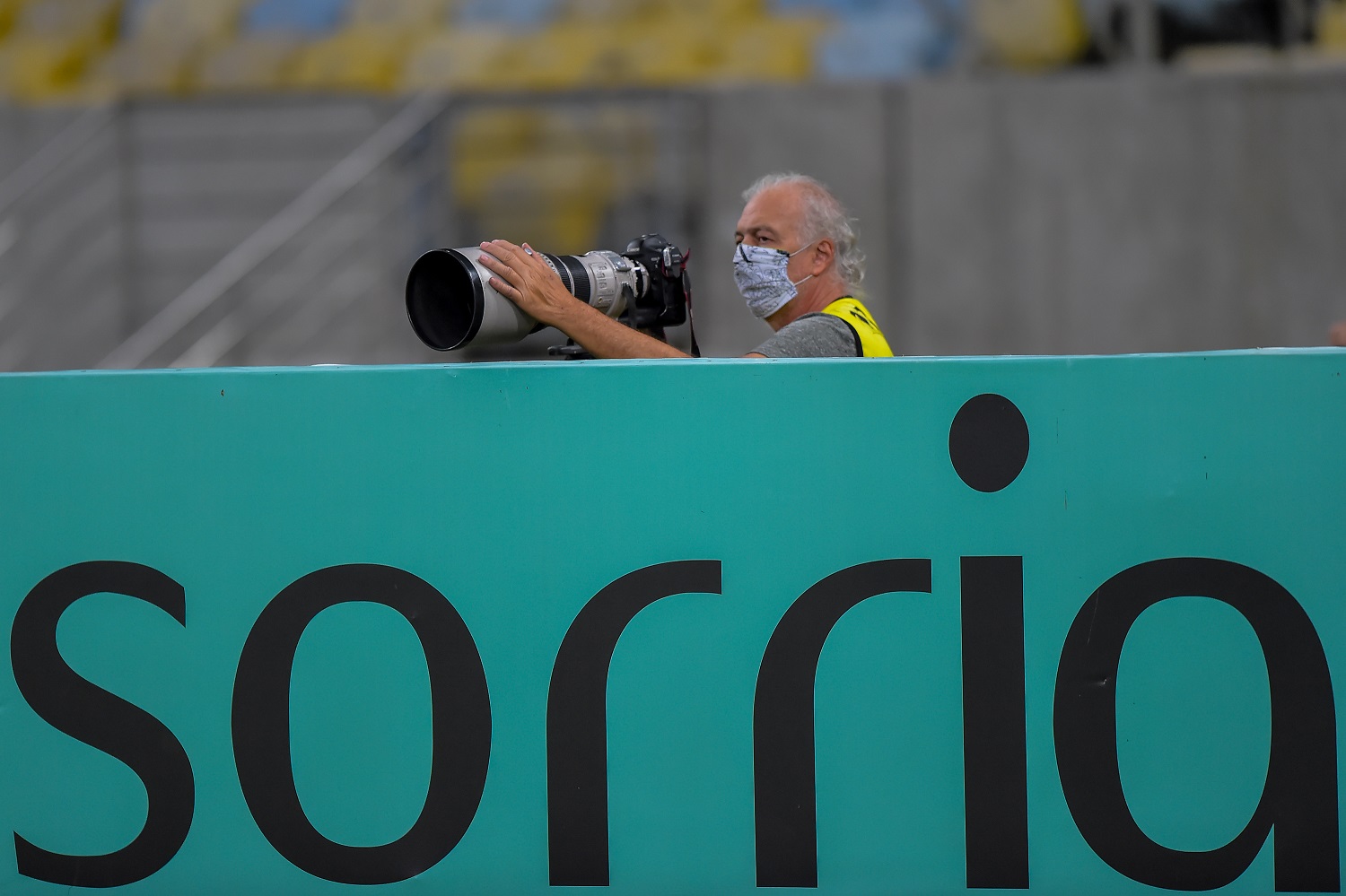 Fotógrafo usa máscara especial de proteção na cobertura do jogo entre Flamengo e Bangu no Maracanã. Foto Thiago Ribeiro/AGIF