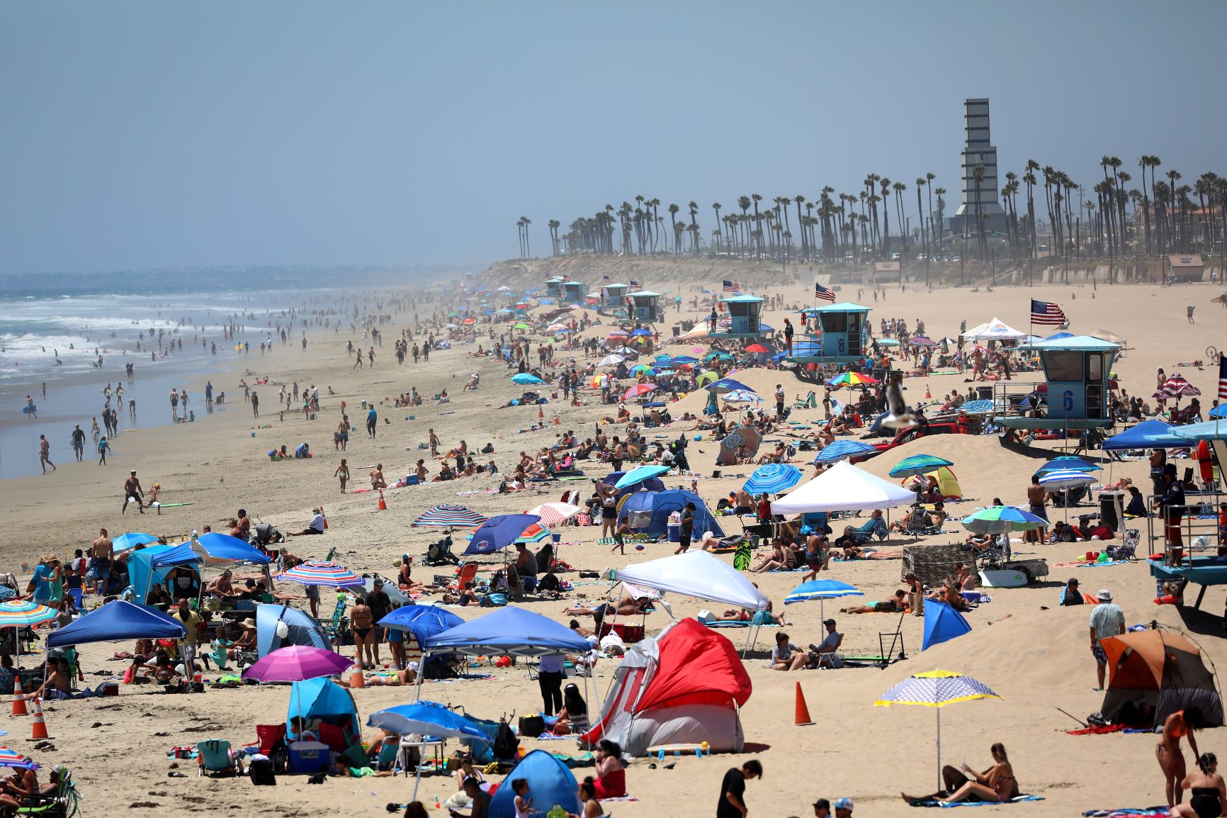 Californianos lotam a Huntington Beach, uma das poucas abertas no feriado: Califórnia retoma medidas restritivas (Foto: Michael Heiman/Getty Images/AFP)