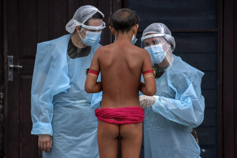 Membros da equipe médica das Forças Armadas conversam com um indígena da etnia Yanomami em um pelotão especial de fronteira, onde estão sendo realizados testes para a covid-19, em Roraima. Foto Nelson Almeida/AFP