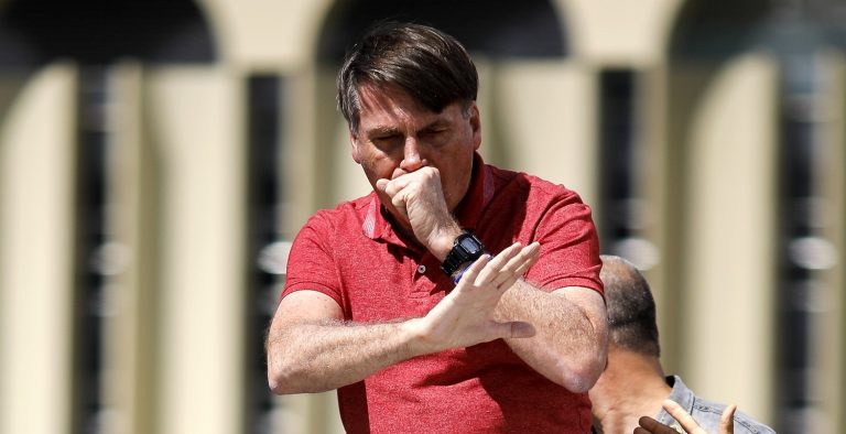 Em imagem feito no dia 19 de abril, em Brasília, o presidente Bolsonaro tosse enquanto fala depois de se juntar a seus apoiadores que estavam participando de uma carreata para protestar contra medidas de quarentena e distanciamento social para combater o novo coronavírus. Foto Sérgio Lima/AFP