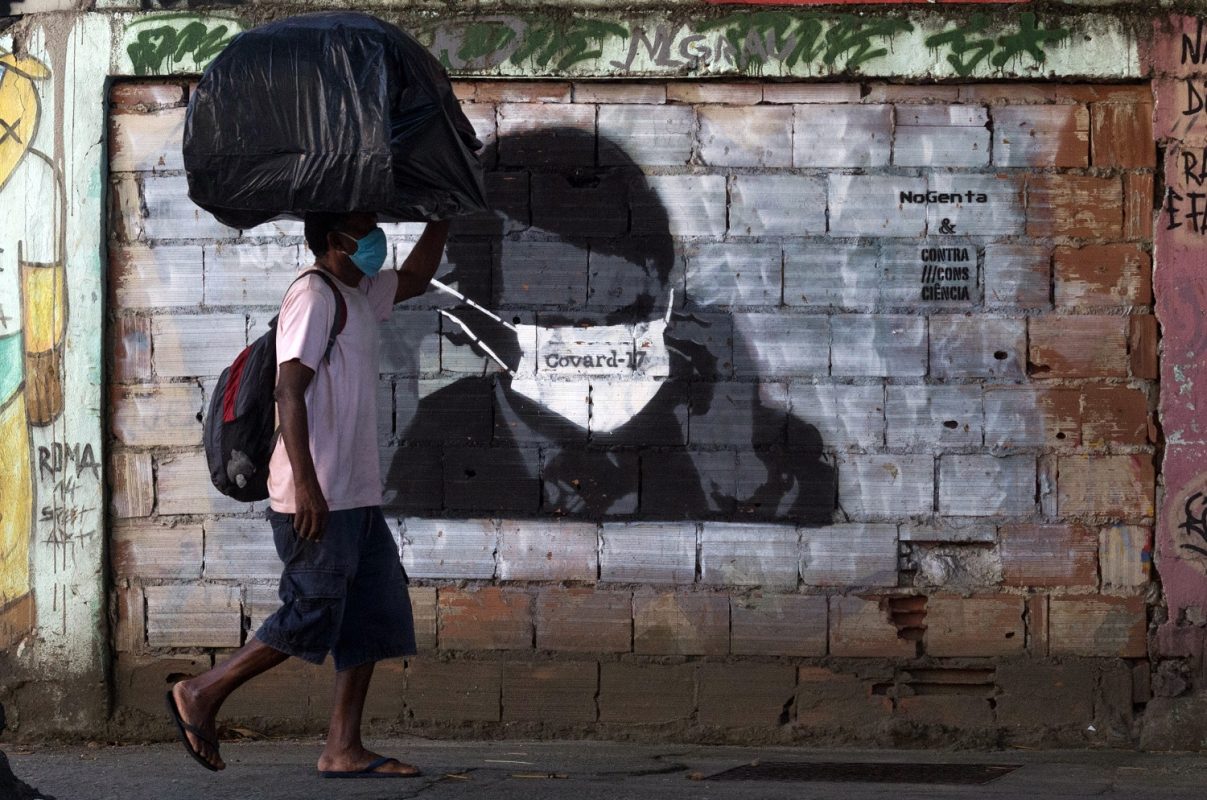 Grafite no Rio de Janeiro mostra o presidente Bolsonaro usando máscara contra a covid-19 sobre o olhos. Foto Bárbara Dias/AGIF