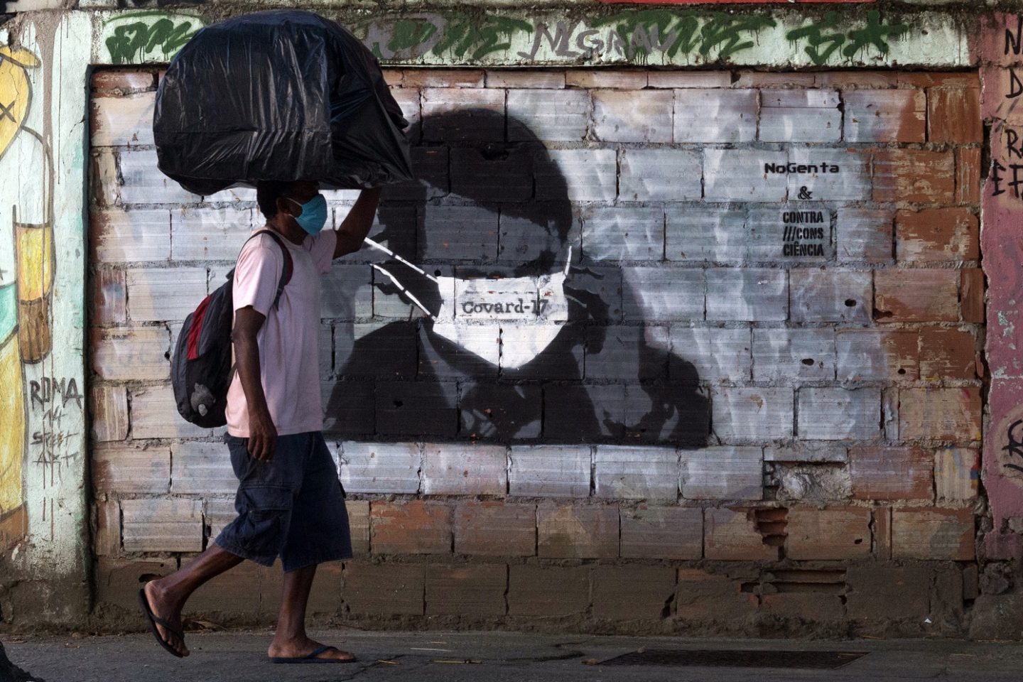 Grafite no Rio de Janeiro mostra o presidente Bolsonaro usando máscara contra a covid-19 sobre o olhos. Foto Bárbara Dias/AGIF