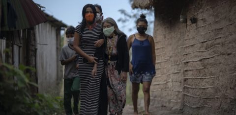 Uma indígena guarani idosa é acompanhada a um posto de saúde para um teste da covid-19 no campo da tribo São Mata Verde Bonita, em Maricá, no Rio de Janeiro. Foto Mauro Pimentel/AFP