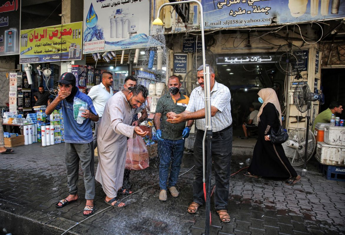 Em Bagdá, no Iraque, homens se refrescam em chuveiro instalado na rua para enfrentar temperatura que passou dos 50 graus em julho: segunda maior temperatura no mês de julho na história (Foto: Ahmad Al-Rubaye/AFP)
