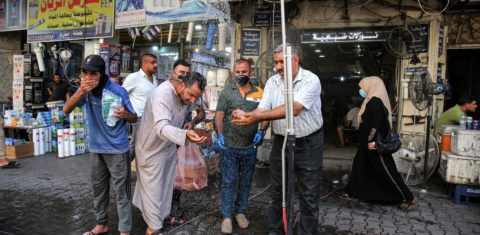 Em Bagdá, no Iraque, homens se refrescam em chuveiro instalado na rua para enfrentar temperatura que passou dos 50 graus em julho: segunda maior temperatura no mês de julho na história (Foto: Ahmad Al-Rubaye/AFP)