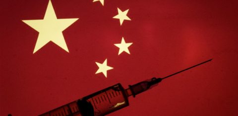 A bandeira da China e uma seringa representando a vacina contra a covid-19: tema de disputa geopolítica (Andrea Ronchini/NurPhoto/ AFP)