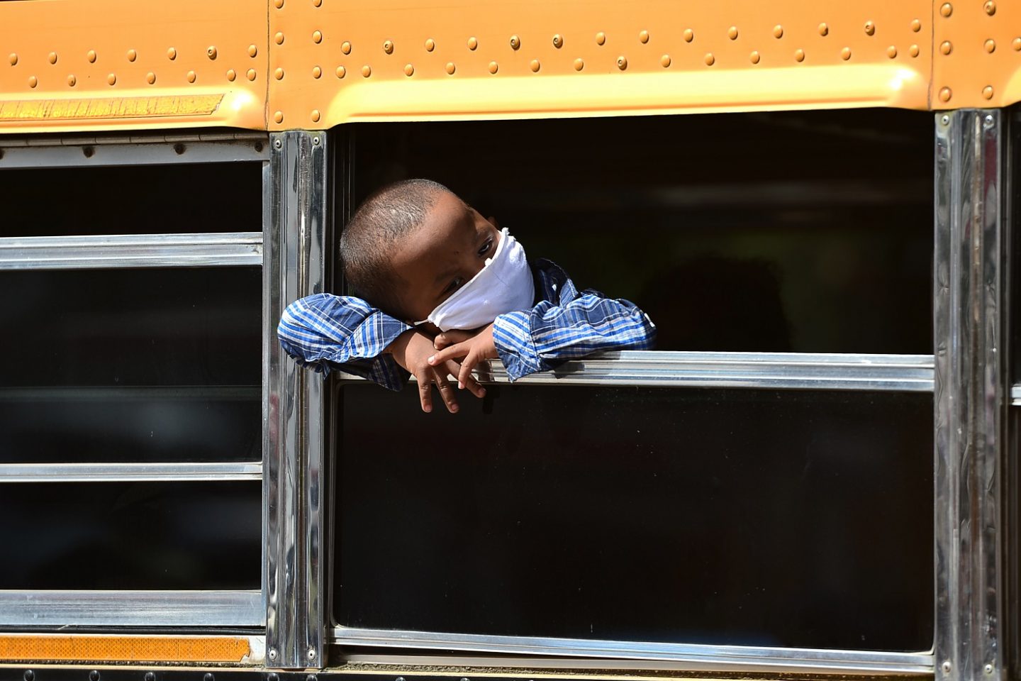 Menino da etnia Miskito olha pela janela de um ônibus na cidade de Tegucigalpa, em Honduras. Foto Orlando Sierra/AFP (Julho/2020)