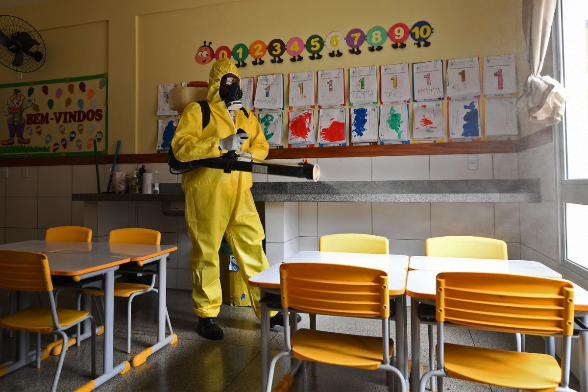 Funcionário do Distrito Federal desinfeta uma escola pública como medida contra a disseminação do novo coronavírus. Foto Evaristo Sá/AFP