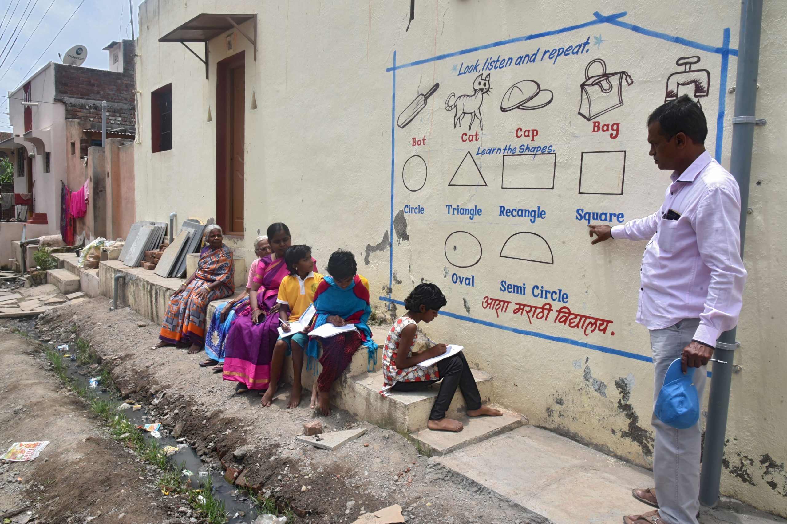 Professor usa parede de casa para dar aula a crianças sem acesso à internet em Solapur, na Índia: 1,5 bilhão de crianças fora da escola no pico da pandemia em todo o mundo (Foto: AFP)