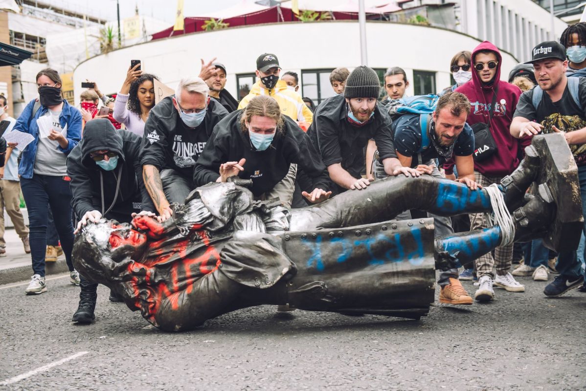Manifestantes derrubam a estátua do traficante de escravos Edward Colston em Bristol: mundo das finanças mantém lógica de tratar a vida de seres humanos como mercadoria (Foto: Giulia Spadafora/NurPhoto/AFP)