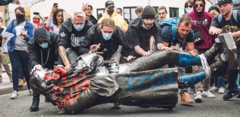 Manifestantes derrubam a estátua do traficante de escravos Edward Colston em Bristol: mundo das finanças mantém lógica de tratar a vida de seres humanos como mercadoria (Foto: Giulia Spadafora/NurPhoto/AFP)