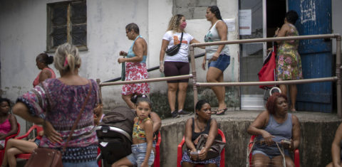 Na Cidade de Deus, grupo de moradores espera pela doação de alimentos distribuídos por uma ONG local. Foto Mauro Pimentel/AFP