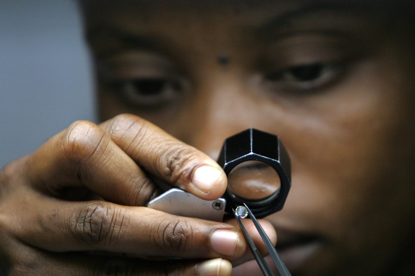 Trabalhadora examina diamante na DTCB, joint venture da mineradora De Beers com o governo de Botsuana. Foto de Alexander Joe (AFP)