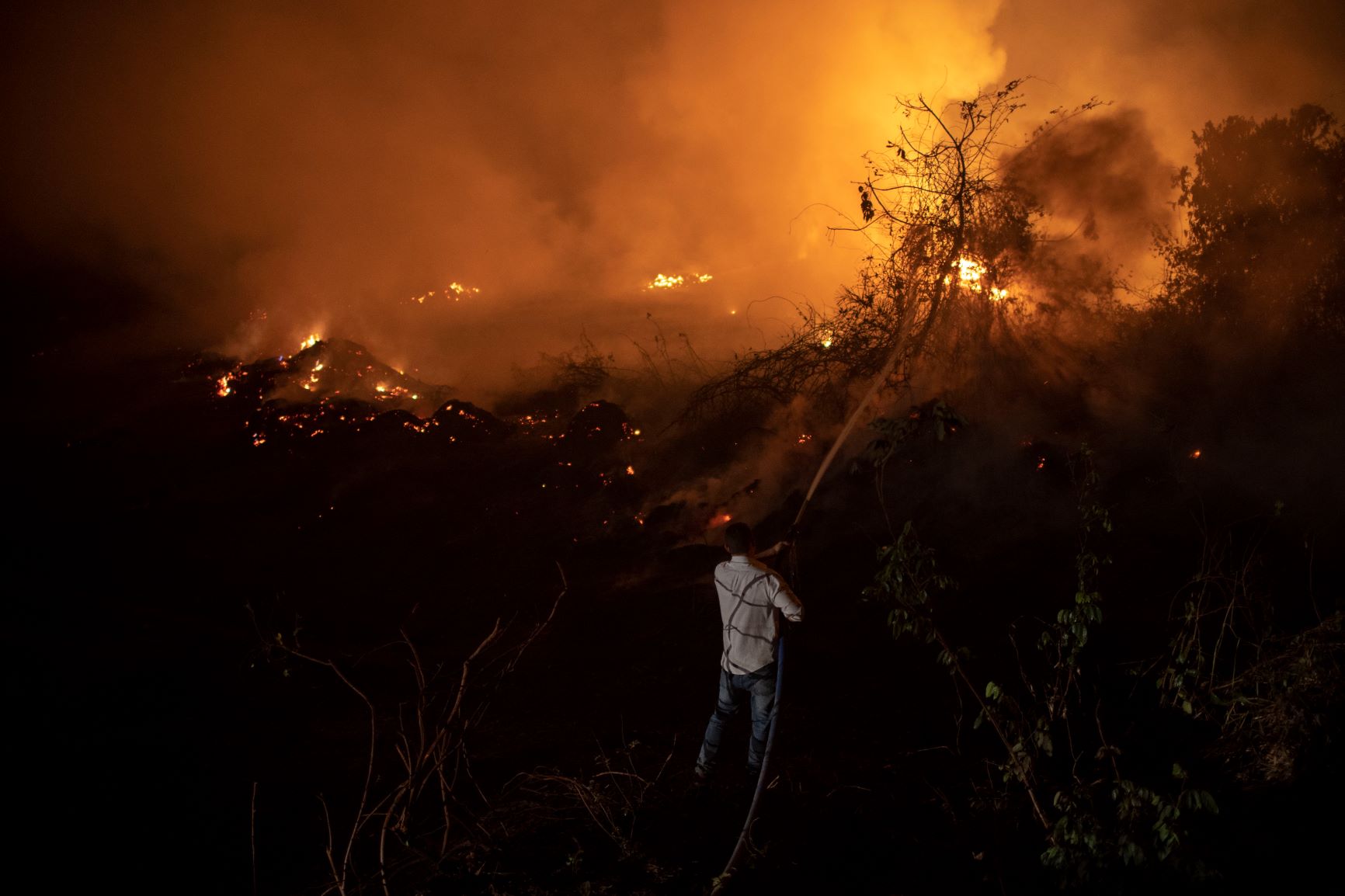 Voluntário tenta apagar fogo perto de ponte da Transpantaneira em Mato Grosso: previsão de anos mais secos em toda a América do Syl (Foto: Mauro Pimentel/AFP)
