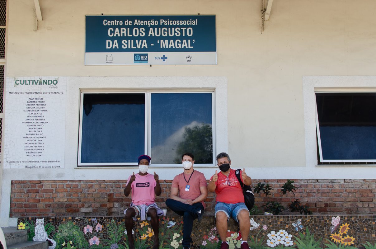 O psiquiatra Carlos César (ao centro) e dois pacientes, em frente ao CAPS Magal, de Manguinhos, que também atende moradores da Maré. Foto de Gabriel Loiola