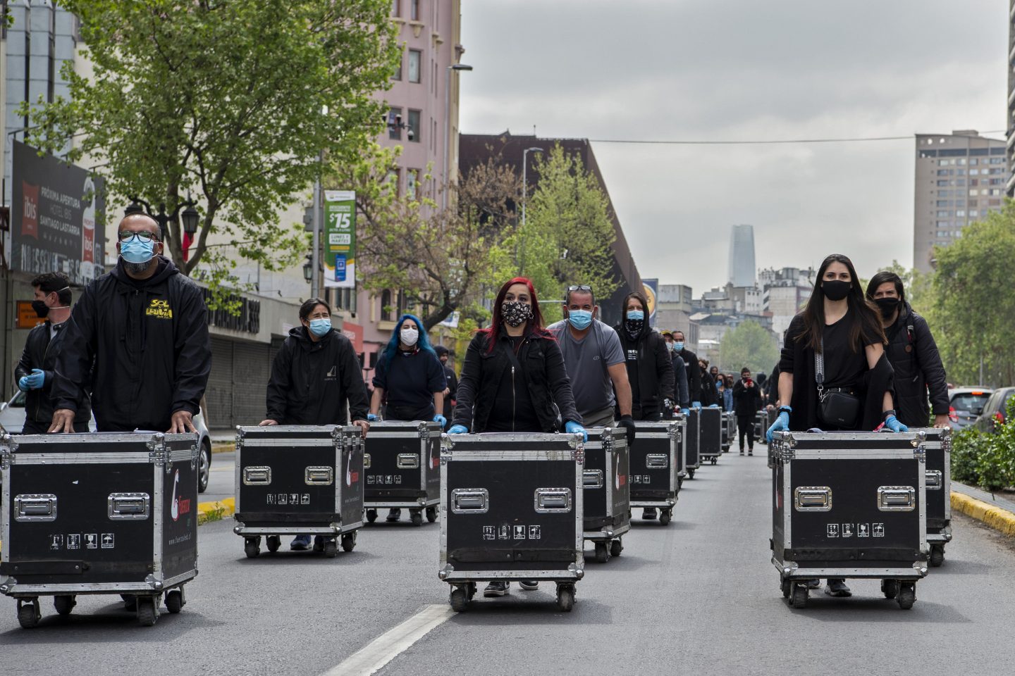 Membros da Associação de Artes e Espetáculos (AGTAE) marcham empurrando caixas com luzes e fios durante um protesto exigindo apoio do governo do presidente chileno Sebastian Pinera para enfrentar a crise provocada pela pandemia. Foto Martin Bernetti/AFP
