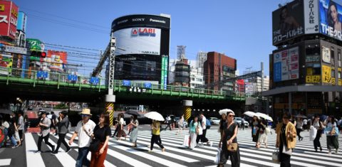 Moradores de Tóquio usam sombrinhas para se proteger de sol no último verão: diferença das ilhas de calor para pontos mais frescos da capital japonesa chega a cinco graus centígrados (Foto: Charly Triballeau/AFP)