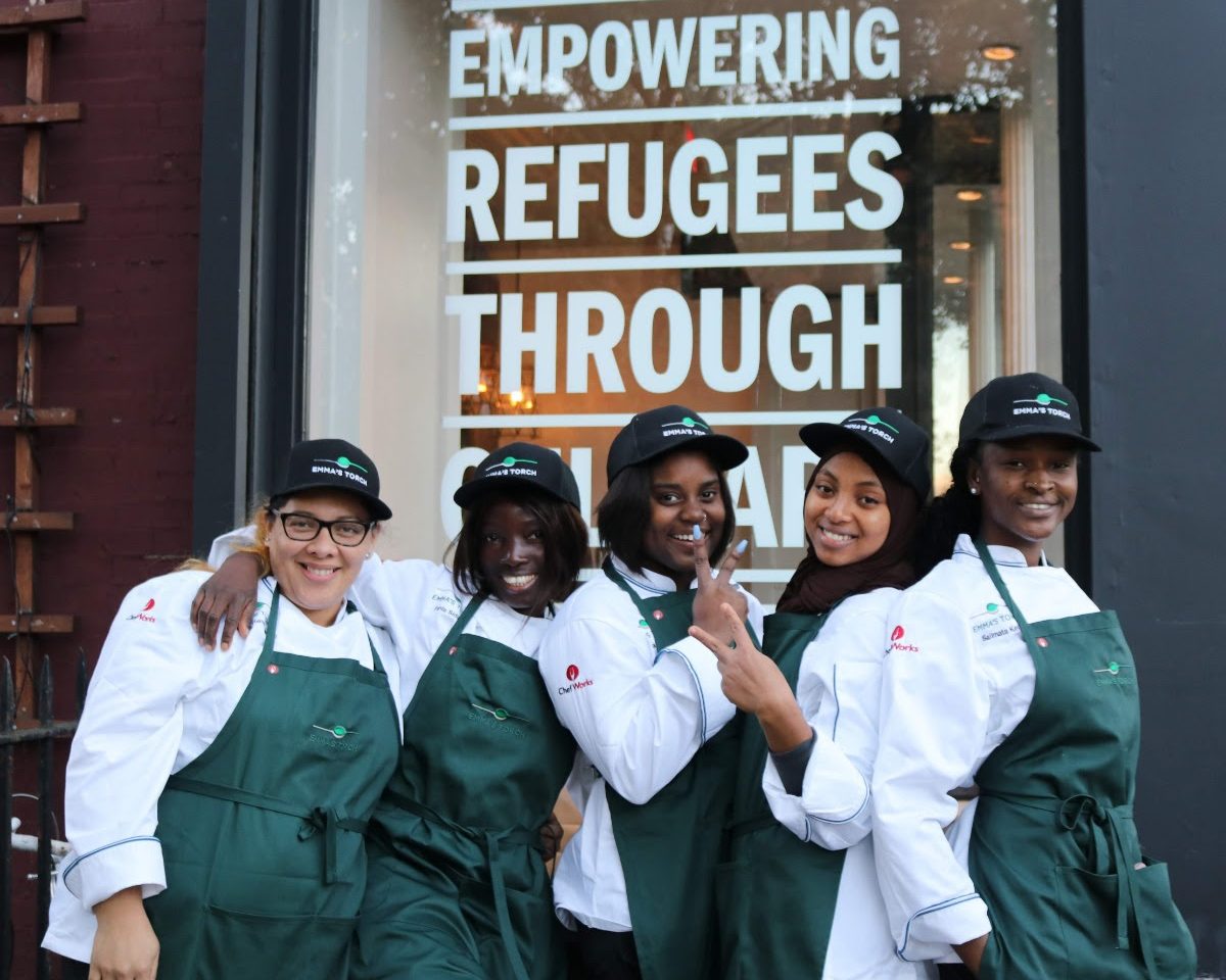 Alunos em frente ao restaurante Emma's Torch: escola de culinária para refugiados, vítimas de tráfico humano e imigrantes em Nova York (Foto: Divulgação)