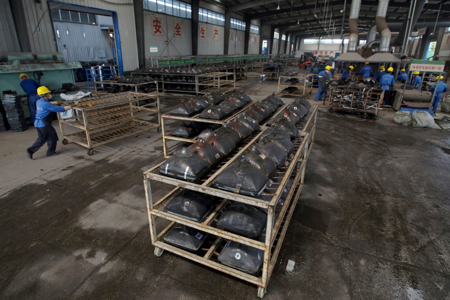 Trabalhadores desmontam aparelhos de TV no Centro Industrial de Economia Circular na China: apenas 8,4% dos materiais que consumimos é reaproveitado (Foto: Zhou Sihan/Imaginechina/AFP)