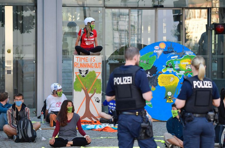 Manifestantes de máscara protestam contra degradação ambiental na Alemanha: pandemia com novo vírus era risco previsível; catástrofe climática é certa (Foto: Thomas Schwarz/AFP)